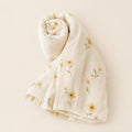 Daisy Daydream Swaddle arranged as a clean baby shower product photo