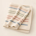 Rainbow Heirloom Knit arranged as a clean baby shower product photo